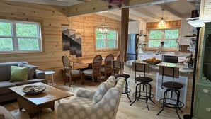 Ein gemütliches Blockhaus-Interieur mit Wohnbereich, Essbereich und Küche.