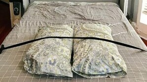A bed with a patterned bedspread, a decorative headboard, and a painting above the bed. - Rittenhouse Modern (Philadelphia)