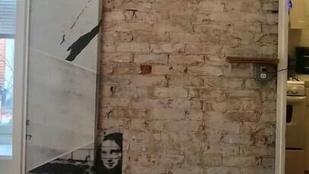 A room with a brick wall and a large poster of a man holding a guitar. The text "RITTENHOUSE MODERN" is visible on the wall. - Rittenhouse Modern (Philadelphia)