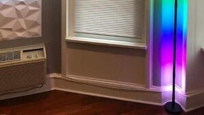 A room with a large window, a mounted TV, and a radiator. - Rittenhouse Modern (Philadelphia)