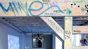 A modern living room with a grey sofa, a small table, and a bookshelf. The walls are adorned with colorful graffiti. - Rittenhouse Modern (Philadelphia)