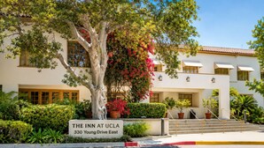 A building with a sign reading 'The Inn at UCLA, 330 Young Drive East' with a tree and potted plants in front. - The Inn at UCLA (Los Angeles)