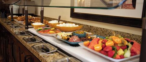 A buffet with various food items and serving utensils.