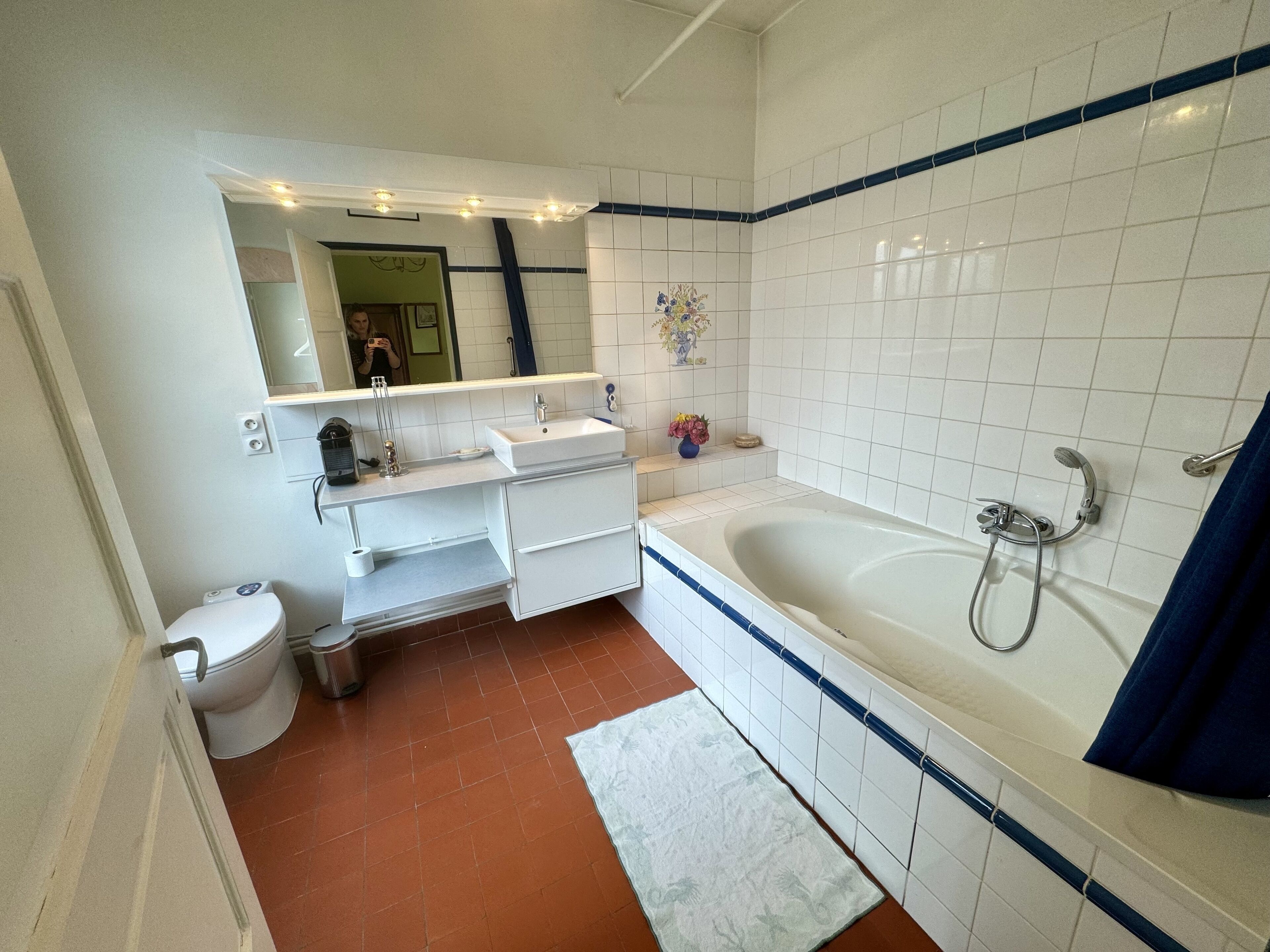 A bathroom with a white sink, mirror, and bathtub.