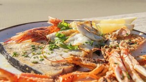 A seafood platter on a plate with a beach view in the background. - B&B POSEIDON (Fiumicino)
