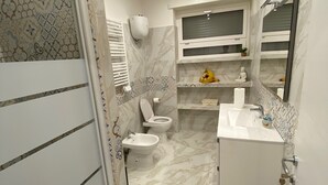 A modern bathroom with a shower, toilet, bidet, and sink. - B&B POSEIDON (Fiumicino)