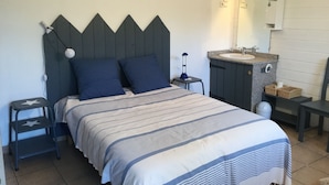 Une chambre à coucher comprenant un lit, une table de chevet, une commode, un miroir et des panneaux indicateurs sur le mur.