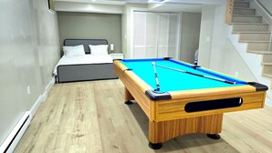 A room with a pool table, a bed, and a staircase. - Updated 3Bedroom. 5beds group ready.Walk to the Casino and play game of Pool. (Springfield)