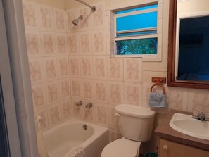 A bathroom with a bathtub, toilet, and sink. - PARADISE CREEK COTTAGES (Andros Town)