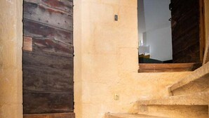 Eine Steintreppe führt zu einer Holztür mit einem Fenster darüber.