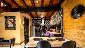 Een moderne keuken met houten balken, een stenen muur en een grote klok.