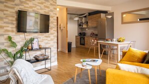 A modern apartment with a living room, dining area, and kitchen. - Le Sarladais - Air conditioning and parking (Sarlat-la-Canéda)