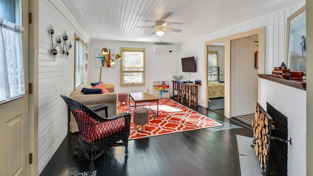 A living room with a sofa, chairs, a coffee table, and a fireplace. - Orr's Island Ocean Views (Orr's Island)