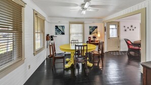 A dining area with a yellow table, wooden chairs, and a ceiling fan. - Orr's Island Ocean Views (Orr's Island)