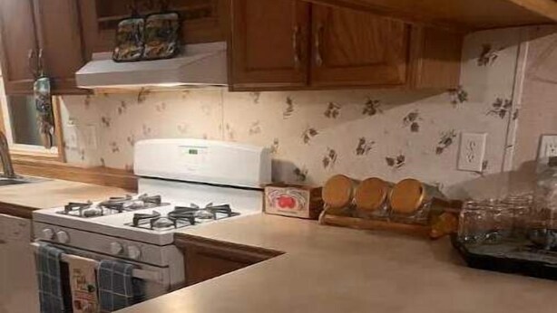 A kitchen with wooden cabinets, a stove, and a countertop. - 4-bedroom farm stay 20 minutes from Cooperstown All Star Village Fields (Morris)