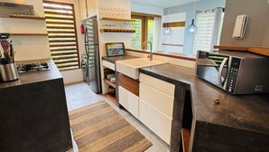 Eine moderne Küche mit einem Edelstahl-Kühlschrank, einer Mikrowelle und einem Spülbecken.