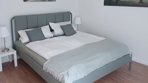 Ein Schlafzimmer mit einem Bett, Nachttischen und zwei an der Wand befestigten Bildern.
