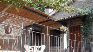 A balcony with a metal railing, a potted plant, and a table with chairs. - Casa Serafina Typical Three-room Apartment Historic Green Area (Orvieto)