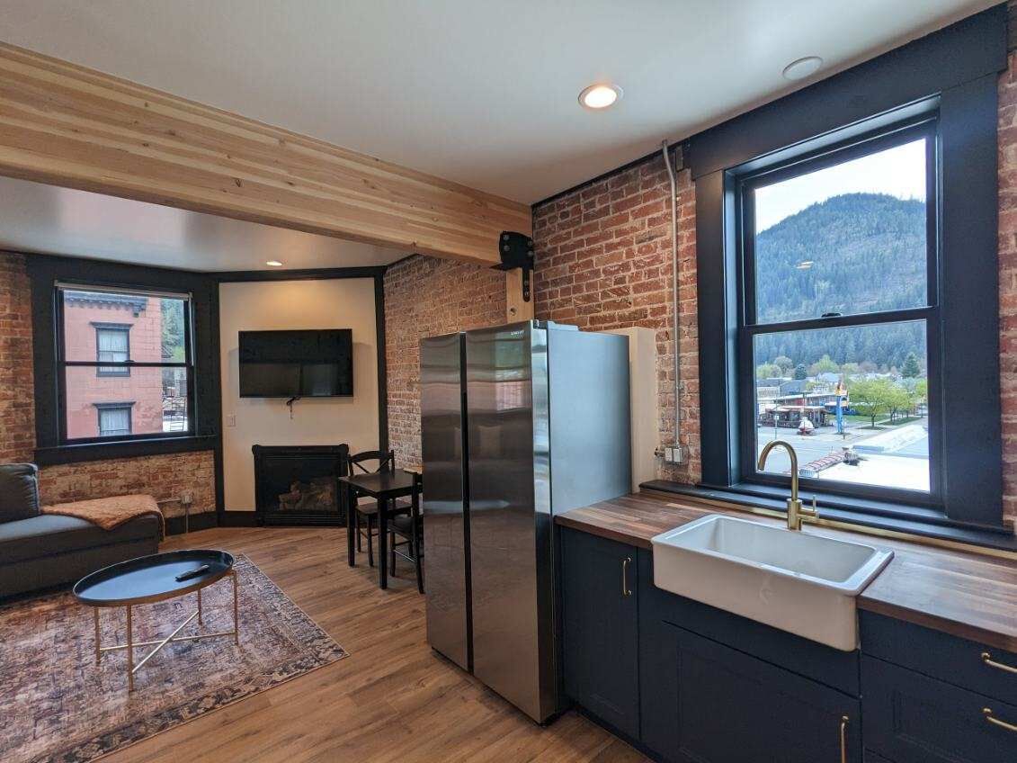 A modern kitchen with a large window, a built-in oven, and a sink.