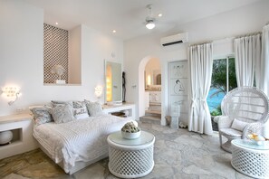 Ein modernes Schlafzimmer mit einem großen Bett, zwei runden Nachttischen, einem dekorativen Spiegel und Blick auf einen Pool durch das Fenster.