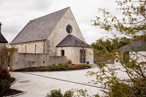 A building with a triangular roof and a circular window. - The Old Kirk and Manse, Hollymount (Hollymount)