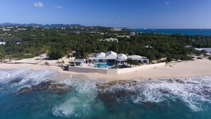 Une propriété située sur la côte, comprenant une grande maison, une piscine et un accès à la plage.