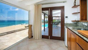 Eine moderne Küche mit Blick auf Strand und Pool.