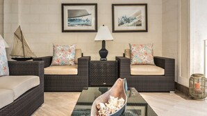 A furnished living room with two sofas, a coffee table, and a decorative sailboat.