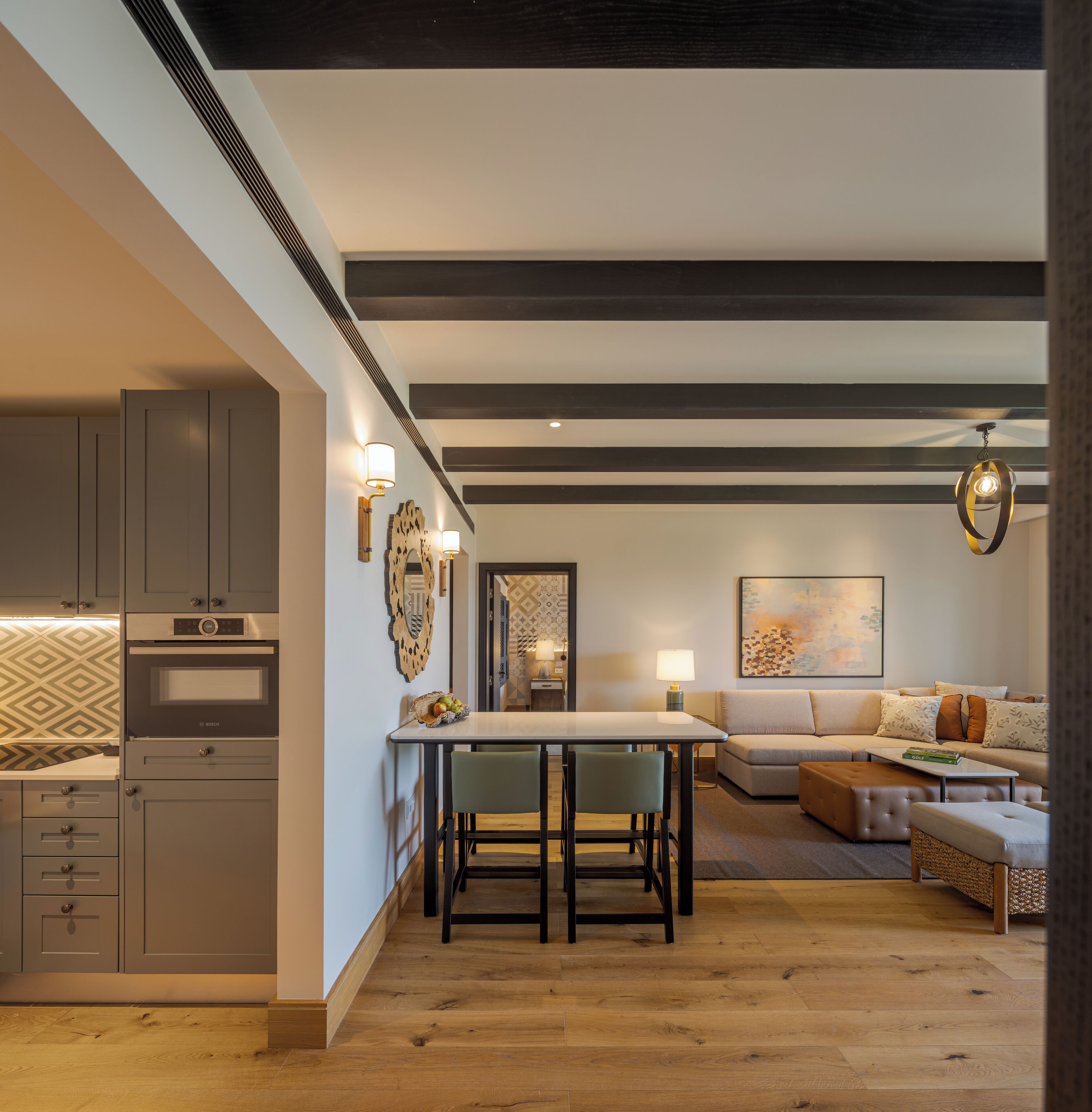 A modern kitchen with built-in appliances, a dining area with a table and chairs, and a living room with a sofa and a coffee table.