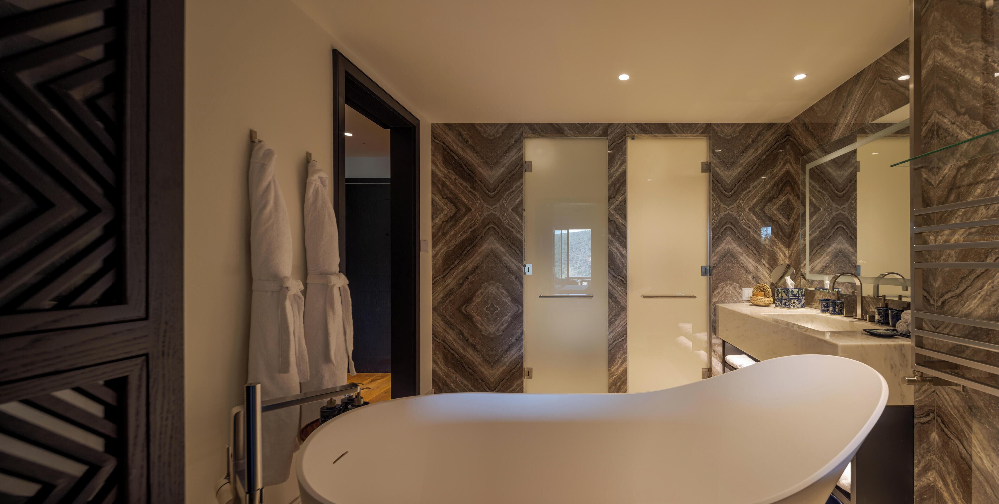 A modern bathroom with a freestanding bathtub, a vanity with a mirror, and a shower area.