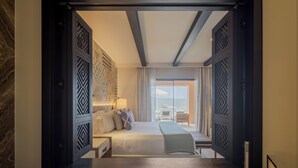 A modern hotel room with a large bed, a desk, and a view of the outdoors.