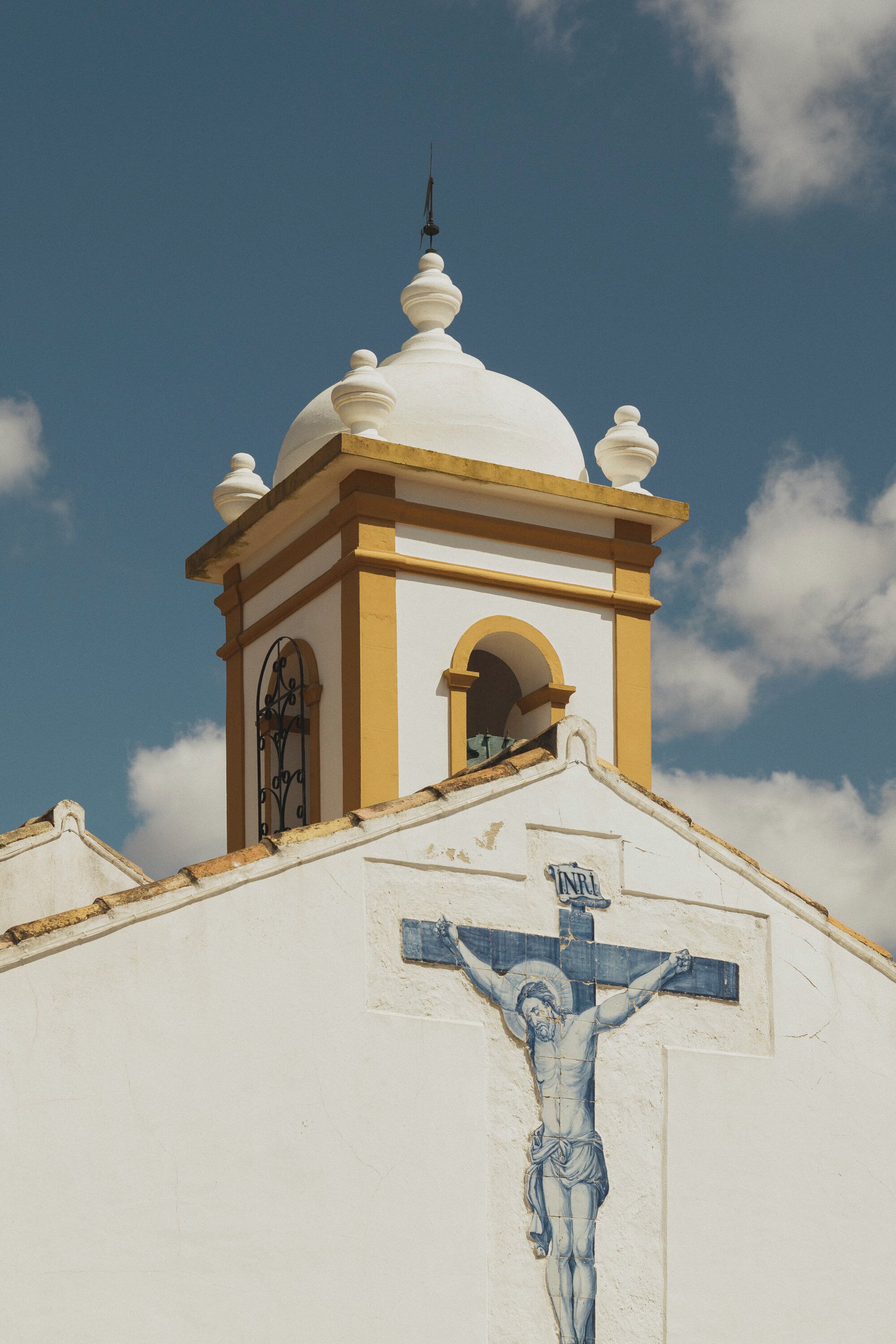 A church with a cross and a bell tower.