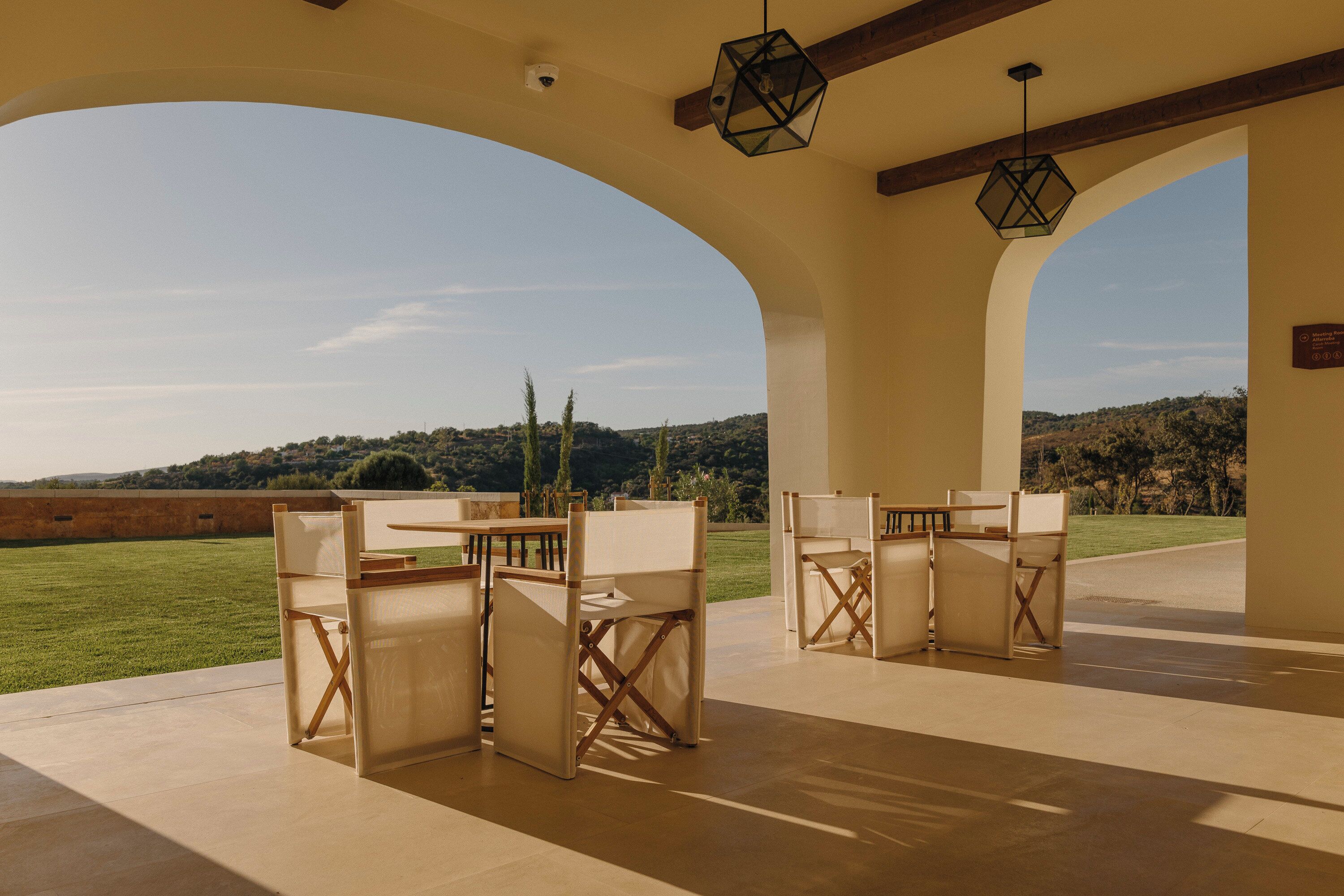Une terrasse extérieure offrant une vue sur la campagne, avec une table et des chaises disposées pour les repas.
