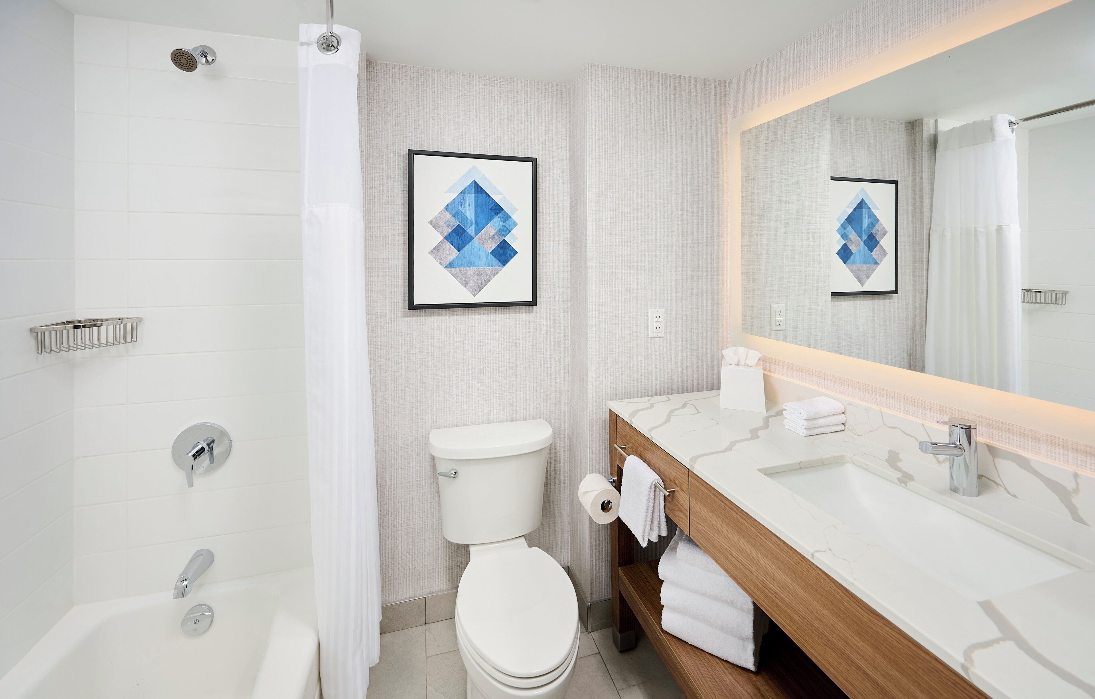 A modern bathroom with a shower, toilet, and vanity.