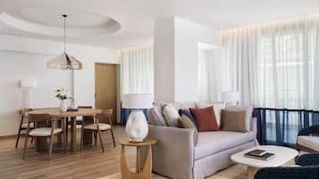 Una sala de estar moderna con un sofá, sillones, una mesa de centro, una mesa de comedor con sillas y una lámpara.