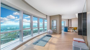 A spacious room with large windows, a yoga mat, exercise ball, and a desk with a chair. - EVEN Hotel Yinchuan Yuehai by IHG (Yinchuan)