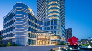 A modern hotel with a curved facade, large glass windows, and a prominent entrance. - EVEN Hotel Yinchuan Yuehai by IHG (Yinchuan)