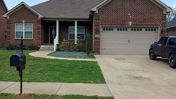 A residential house with a brick facade, a garage, and a driveway.