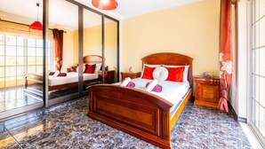 A hotel room with a large bed, a mirror, a red pendant light, and a view of the outside. - Villa Dubai (Albufeira)