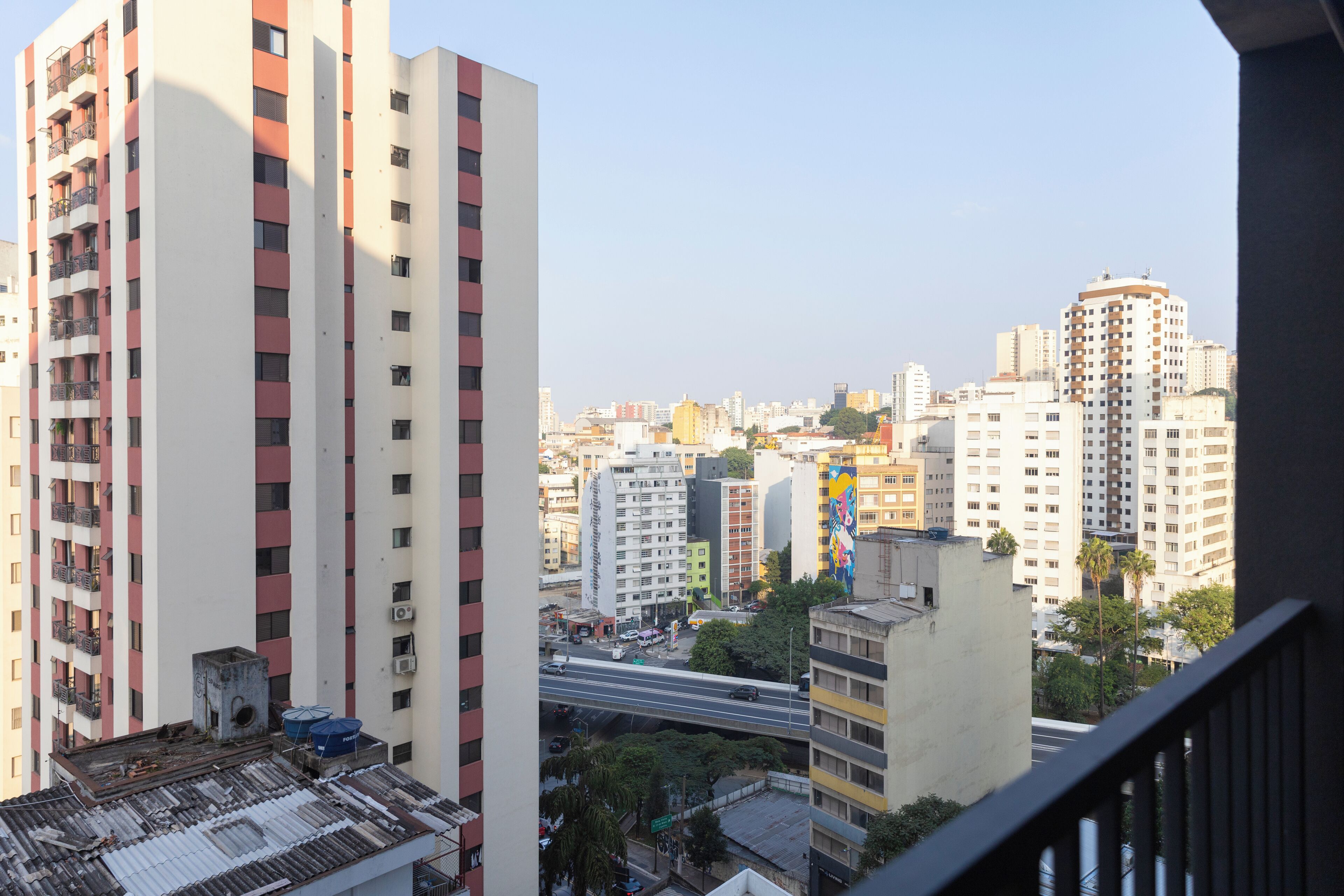 A high-rise building with a view of a cityscape, including other tall buildings and a bridge.