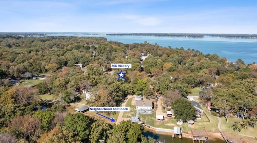 An aerial view of a residential area with a house labeled "308 Hickory" and a nearby boat dock.
