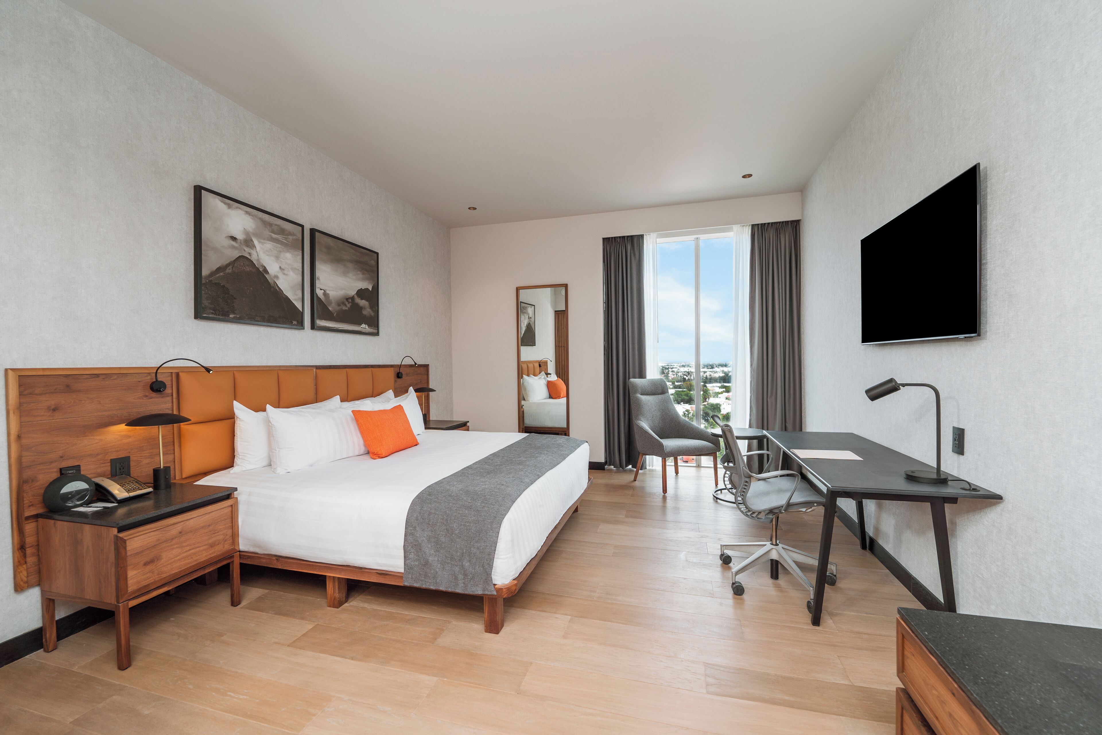 Une chambre d’hôtel équipée d’un lit, d’un bureau, d’une chaise et d’un téléviseur.