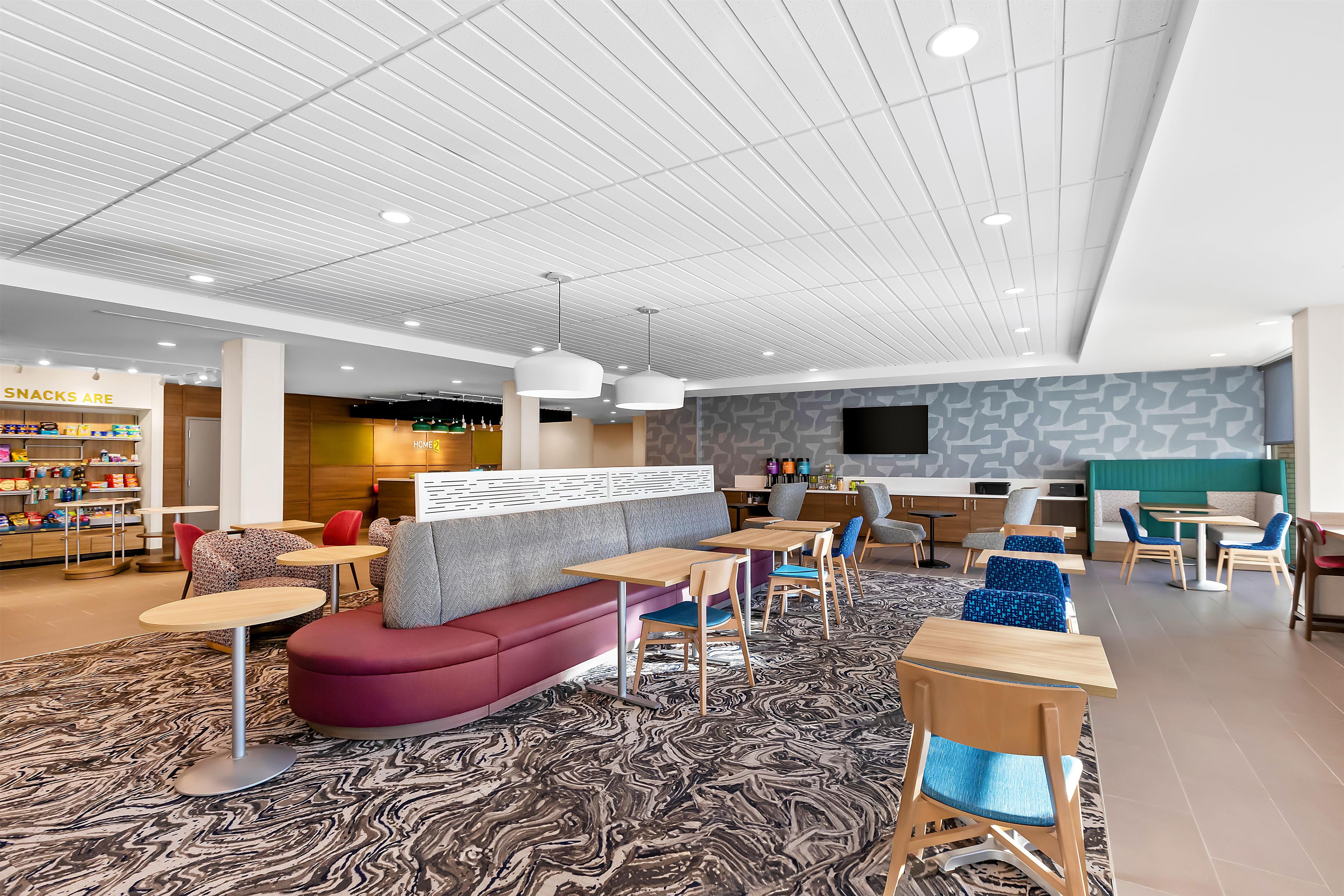 A modern lounge area with seating, tables, and a snack bar.