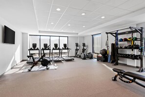 Ein modernes Fitnessstudio mit Laufbändern, Ergometer und Gewichten.