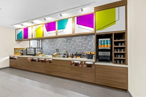 Una cocina moderna con una encimera larga, electrodomésticos integrados y una gran variedad de utensilios y recipientes.
