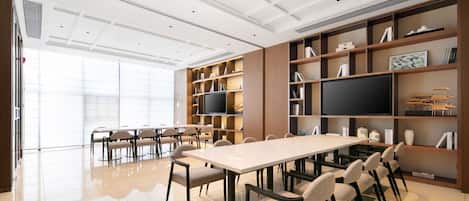 A modern conference room with a large table, chairs, and built-in shelving with books and decorative items.