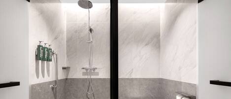 A modern bathroom with a shower, toilet, and towel rack.