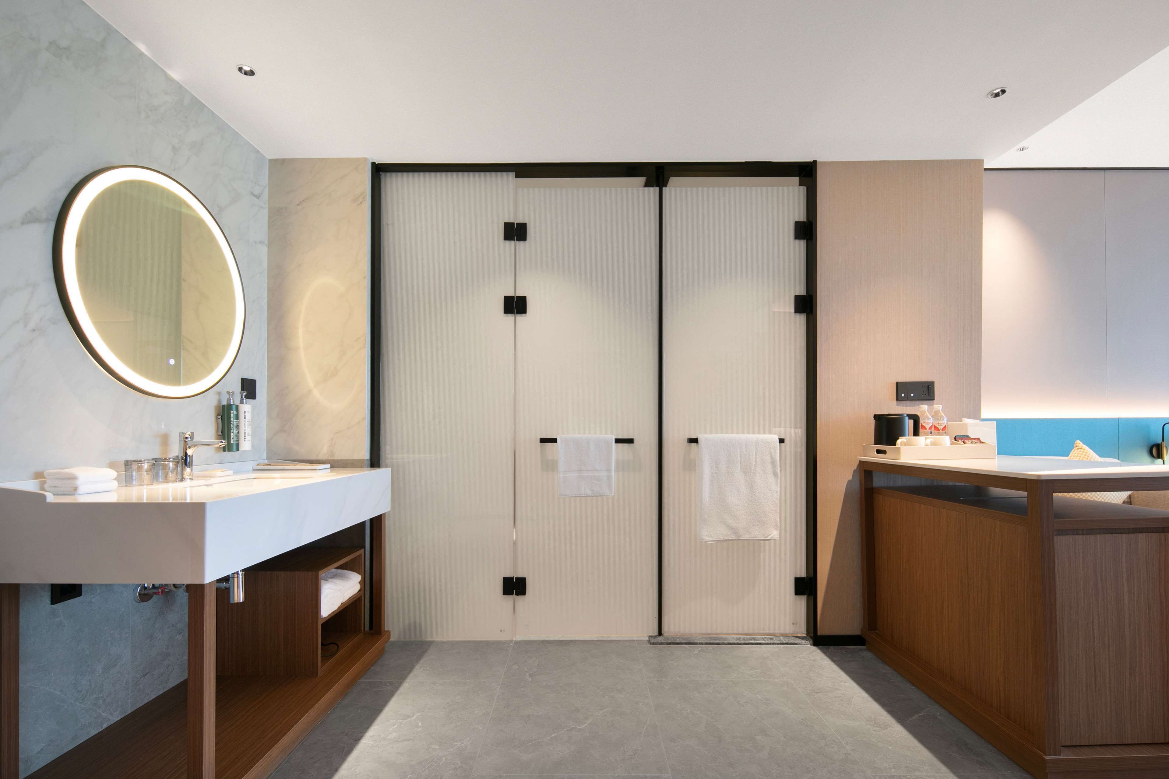 Un bagno moderno con doppio lavabo, uno specchio grande e un porta asciugamani.