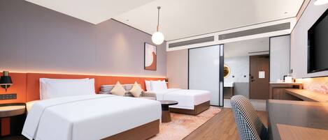 A modern hotel room with two beds, a desk, a chair, and a television.