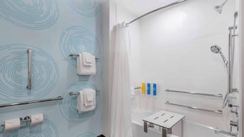 A modern bathroom with a shower, a bathtub, and a toilet paper holder.